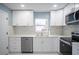 Updated kitchen features modern stainless steel appliances and white cabinets at 20004 Harvie Ln, Lutz, FL 33558