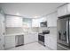 Well-lit kitchen features stainless steel appliances, white cabinets, and marble backsplash at 20004 Harvie Ln, Lutz, FL 33558