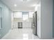 Modern kitchen with stainless steel appliances, white cabinets, and marble-style flooring at 20004 Harvie Ln, Lutz, FL 33558