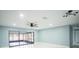 Open living room with modern lighting, fresh paint, and access to a screened-in lanai at 20004 Harvie Ln, Lutz, FL 33558