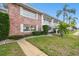 Two-story condo featuring a brick facade, lush landscaping, and inviting walkway at 211 Brandy Wine Dr # 211, Largo, FL 33771