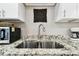 Close-up of a kitchen sink with granite countertops and stainless steel fixtures at 211 Brandy Wine Dr # 211, Largo, FL 33771