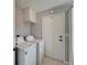 Bright laundry room with a white washer and dryer, cabinet storage, and exterior access at 2115 Hereford Dr, Sun City Center, FL 33573