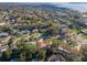 Expansive aerial view of a neighborhood with mature trees, lush lawns, and homes near the water at 220 Garden S Cir, Dunedin, FL 34698