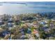 Bright aerial view showcasing homes in a quiet neighborhood near a scenic body of water at 220 Garden S Cir, Dunedin, FL 34698