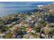 Aerial view showing houses with vibrant lawns in a neighborhood near the waterfront and beach at 220 Garden S Cir, Dunedin, FL 34698