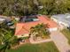 Bird's-eye view of the home showcasing its terra cotta roof, pool, and lush surroundings at 220 Garden S Cir, Dunedin, FL 34698