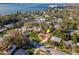 Aerial shot of the home, near a body of water, nestled among lush green trees and landscaping at 220 Garden S Cir, Dunedin, FL 34698