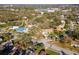 Aerial view of the neighborhood and homes nestled among lush greenery on a sunny day at 220 Garden S Cir, Dunedin, FL 34698