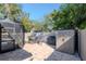 Paver patio in backyard has grill, shed, and covered porch area with view of the trees at 220 Garden S Cir, Dunedin, FL 34698