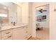 Bright bathroom with a granite countertop vanity and a doorway leading to a cozy bedroom with neutral decor at 220 Garden S Cir, Dunedin, FL 34698