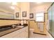 Classic bathroom featuring yellow tile, black countertops, and a shower with a sliding glass door at 220 Garden S Cir, Dunedin, FL 34698