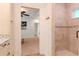 Elegant bathroom featuring a tiled shower and a glimpse into the neutral-toned bedroom with a ceiling fan at 220 Garden S Cir, Dunedin, FL 34698