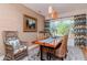 Bright dining room with a wooden table, woven chairs, and patterned curtains at 220 Garden S Cir, Dunedin, FL 34698