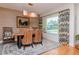 Dining room featuring a wooden table, woven chairs, and patterned curtains near a window at 220 Garden S Cir, Dunedin, FL 34698