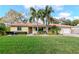 Inviting one-story home features a well-manicured lawn and mature landscaping at 220 Garden S Cir, Dunedin, FL 34698