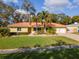 Charming single story home with vibrant landscaping, a well-manicured lawn, and a driveway at 220 Garden S Cir, Dunedin, FL 34698
