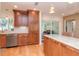 Well-lit kitchen featuring wood cabinets, stainless steel appliances, light countertops, and hardwood floors at 220 Garden S Cir, Dunedin, FL 34698
