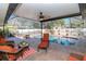 Inviting screened-in pool area with ample seating, a ceiling fan, and lush landscaping for outdoor relaxation at 220 Garden S Cir, Dunedin, FL 34698