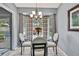Bright dining area with chandelier has a glass top table and backyard view at 2343 Hidden Trail Dr, Spring Hill, FL 34606