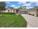 Charming front exterior with lush lawn, and a well-maintained driveway leading to the garage at 2343 Hidden Trail Dr, Spring Hill, FL 34606