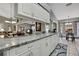 Modern kitchen with white cabinets, granite countertops, and an open view to the dining and living areas at 2343 Hidden Trail Dr, Spring Hill, FL 34606
