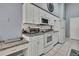 Well-lit kitchen features white cabinets and appliances with stylish granite countertops at 2343 Hidden Trail Dr, Spring Hill, FL 34606