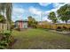 A spacious backyard featuring a shed, tropical foliage, a fire pit, and a well-maintained lawn at 2454 15Th N Ave, St Petersburg, FL 33713