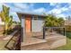 Backyard shed with a wooden deck and an orange door, surrounded by tropical plants at 2454 15Th N Ave, St Petersburg, FL 33713