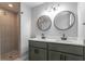 Well-appointed bathroom with a dual sink vanity, tiled shower and stylish round mirrors at 2454 15Th N Ave, St Petersburg, FL 33713