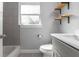 Well-lit bathroom showcases tiled walls, bathtub, vanity with modern fixtures, and open shelving at 2454 15Th N Ave, St Petersburg, FL 33713