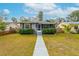 Charming single-story home with gray siding, decorative shutters, manicured hedges and a walkway leading to the front door at 2454 15Th N Ave, St Petersburg, FL 33713