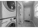 Convenient laundry room features stacked washer and dryer, tile flooring, and a rear door at 2454 15Th N Ave, St Petersburg, FL 33713