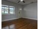 Bright living room featuring hardwood floors, a ceiling fan, and a large window offering natural light at 2454 15Th N Ave, St Petersburg, FL 33713