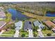 Aerial view showcasing homes with screened pools, lush landscaping, and lake views in a residential neighborhood at 31101 Wrencrest Dr, Wesley Chapel, FL 33543