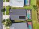Aerial view of a home featuring a screened pool, solar panels, and a well-maintained yard at 31101 Wrencrest Dr, Wesley Chapel, FL 33543