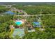 Community aerial view showcasing pool, tennis courts, and recreational facilities surrounded by lush greenery at 31101 Wrencrest Dr, Wesley Chapel, FL 33543