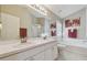 Bright bathroom with double sinks, white cabinetry, a soaking tub, and modern fixtures for relaxation at 31101 Wrencrest Dr, Wesley Chapel, FL 33543