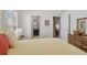 Bright bedroom featuring wood floors, a queen bed, and two open doorways at 31101 Wrencrest Dr, Wesley Chapel, FL 33543