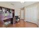 Cozy bedroom featuring wood floors, a built-in desk, and ample closet space at 31101 Wrencrest Dr, Wesley Chapel, FL 33543