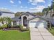 Inviting single-story home featuring a well-kept lawn and a convenient two-car garage at 31101 Wrencrest Dr, Wesley Chapel, FL 33543