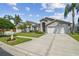 Charming home with landscaped yard, palm trees, and a wide driveway, perfect for Florida living at 31101 Wrencrest Dr, Wesley Chapel, FL 33543