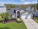 A beautiful home with a two-car garage, surrounded by lush landscaping and palm trees, exudes curb appeal at 31101 Wrencrest Dr, Wesley Chapel, FL 33543