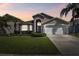Charming single Gathering home with a well maintained lawn and beautiful Florida landscaping at sunset at 31101 Wrencrest Dr, Wesley Chapel, FL 33543