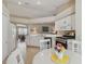 Bright, all-white kitchen featuring stainless steel appliances, tile floors and a casual dining space at 31101 Wrencrest Dr, Wesley Chapel, FL 33543