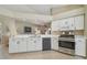 Bright kitchen with white cabinets, stainless steel appliances, and an open layout with views to other rooms at 31101 Wrencrest Dr, Wesley Chapel, FL 33543