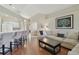 Open-concept living room with wood floors, modern decor, and a breakfast bar leading to the kitchen at 31101 Wrencrest Dr, Wesley Chapel, FL 33543