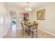 Charming dining area with a chandelier, tile flooring, and an open view into the kitchen at 31229 Claridge Pl, Wesley Chapel, FL 33543