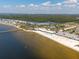 Expansive aerial view captures the beauty of a beach with clear water and a pier for seaside activities at 3230 Mangrove Point Dr, Ruskin, FL 33570