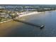 An aerial shot of a beach with a long pier extending into tranquil waters, showcasing a vibrant coastal scene at 3230 Mangrove Point Dr, Ruskin, FL 33570